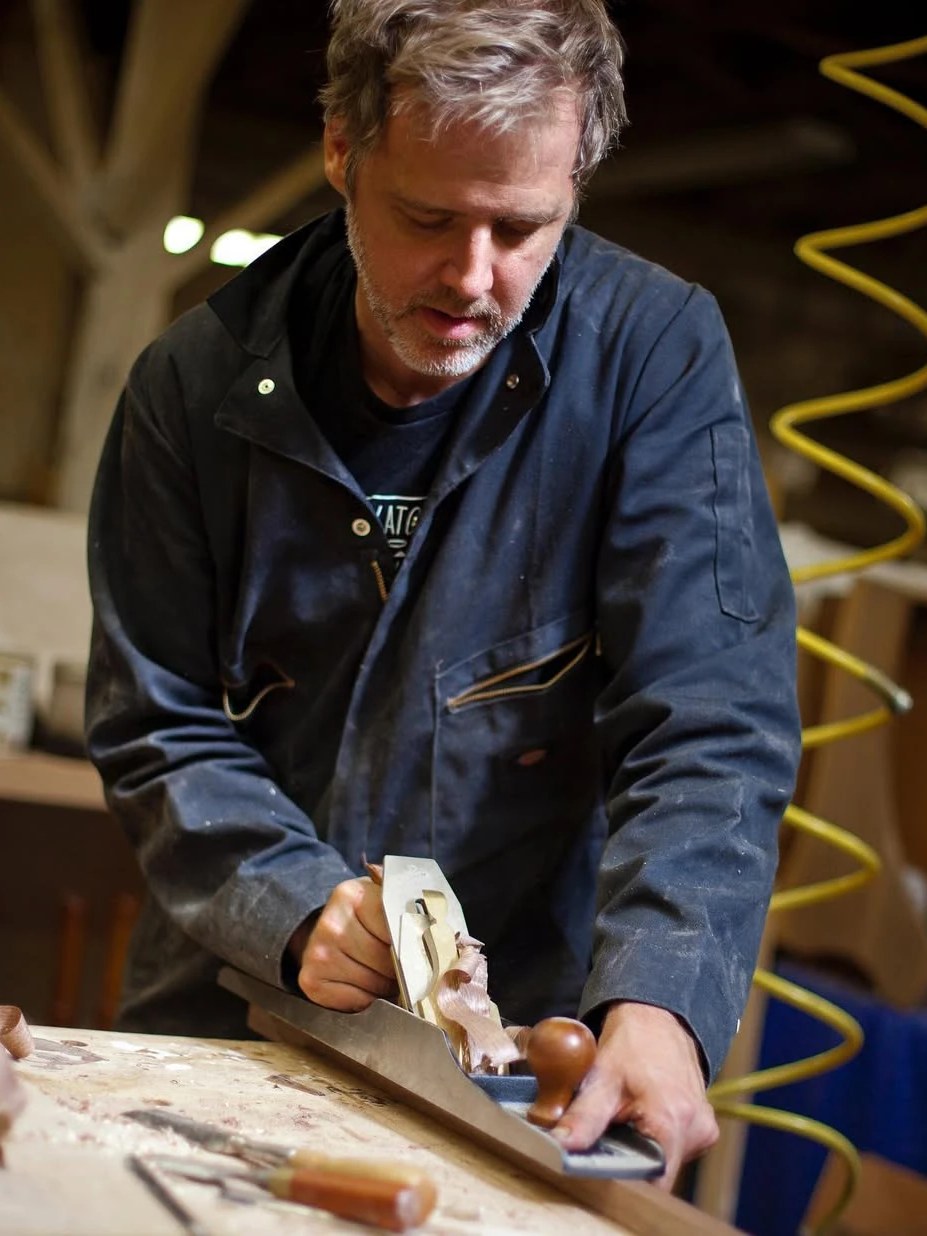 Erik Needham hand planing a board at the bench