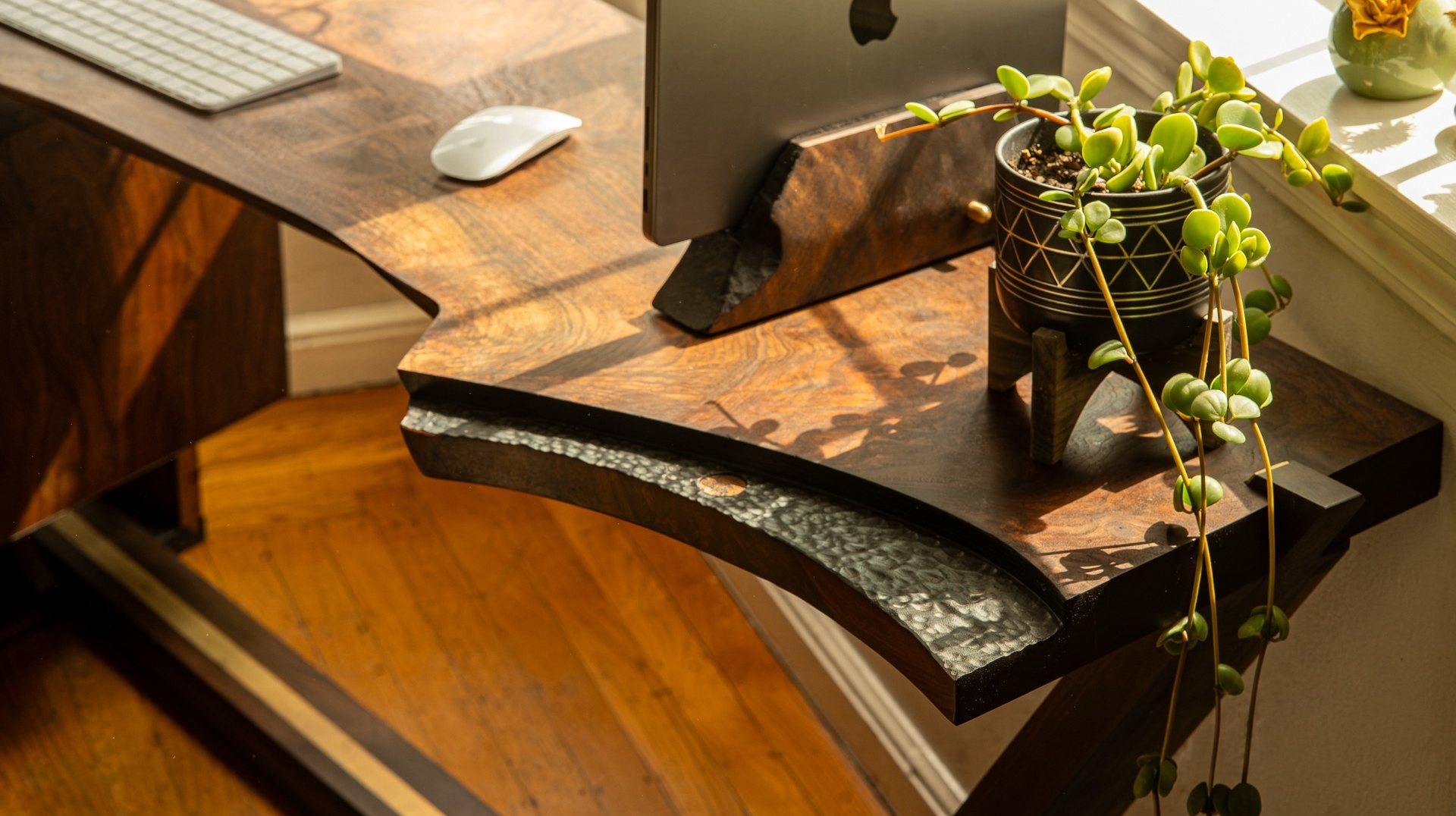 Cantilever leg extending through the claro walnut slab of the Lani Leads desk